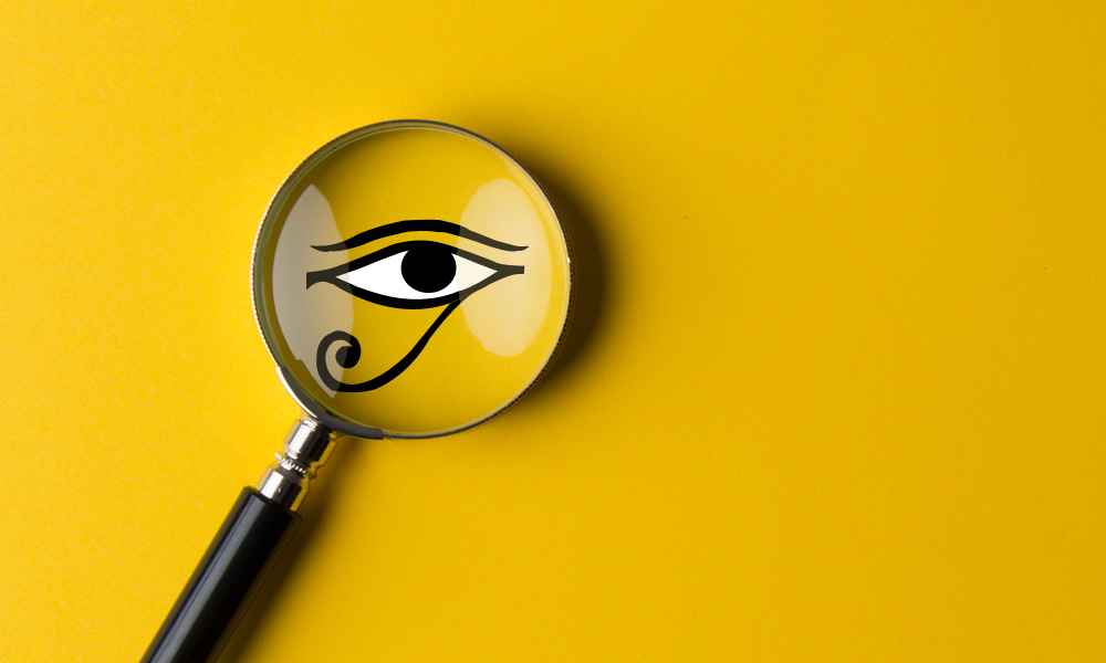 Lupa con ojo egipcio sobre fondo amarillo